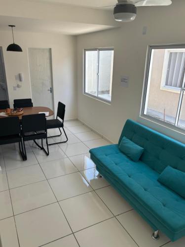 a living room with a blue couch and a table at Casa Delta 187 in Parnaíba