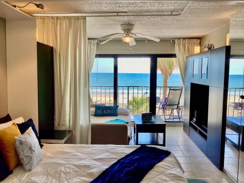 a bedroom with a bed and a view of the ocean at Shoreline Studio Condo for 4 in Galveston
