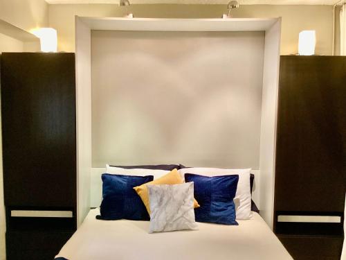 a bed with blue and white pillows on it at Shoreline Studio Condo for 4 in Galveston