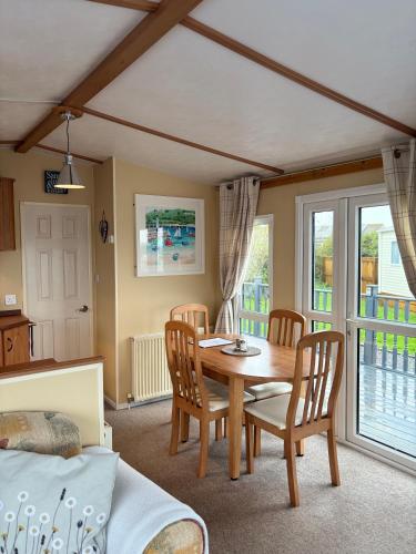 a dining room with a wooden table and chairs at Seaside Escape 2-Bed Caravan at Seven Bays Park in Saint Merryn