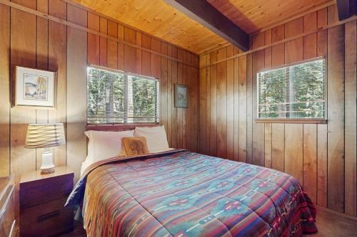 a bedroom with a bed in a wooden cabin at Talmont Trailhead Cabin in Tahoe City