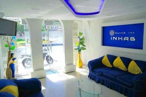 a living room with a blue couch and a tv at Hotel Suite Los Inkas en Arequipa in La Pampilla