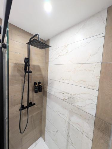 a bathroom with a shower with white marble at Le 1930, la pause Béthunoise in Béthune