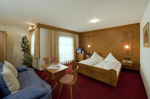a hotel room with a bed and a couch at Hotel Lasalt in Ischgl