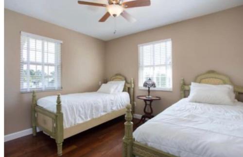 a bedroom with two beds and a ceiling fan at Peace on the River, Breathtaking Views in Cocoa