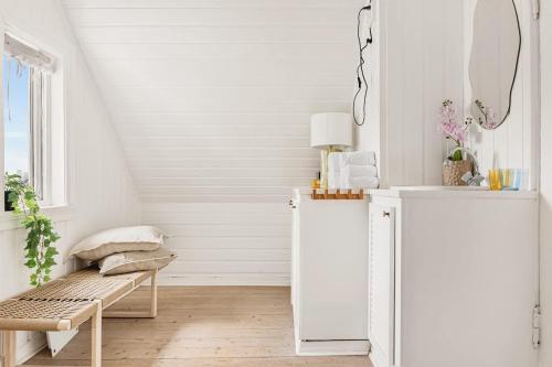 ein weißes Zimmer mit einer Bank und einem Fenster in der Unterkunft The 1880 Authentic Bergen Dream I 500m to Bryggen in Bergen