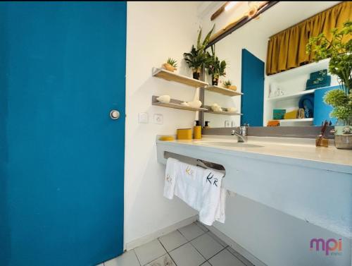 un baño con lavabo y espejo en Pause tropicale, en Le Diamant