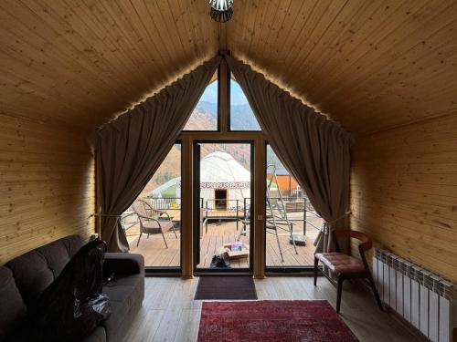 Una sala de estar con un sofá y una ventana grande. en Mountain View - Kolsay, en Kurmenty