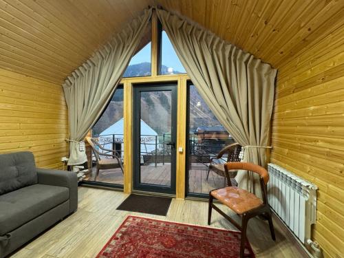 Una sala de estar con un sofá y una ventana grande. en Mountain View - Kolsay, en Kurmenty