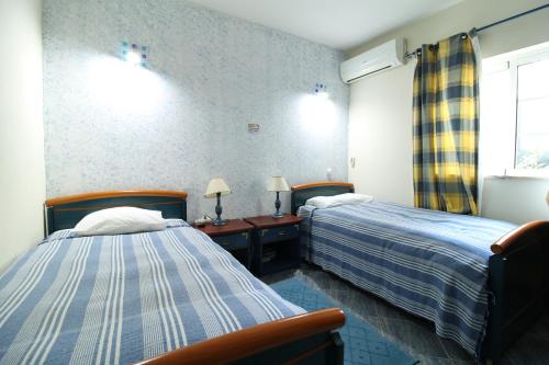 a hotel room with two beds and a window at Alcaria Pool House in Altura