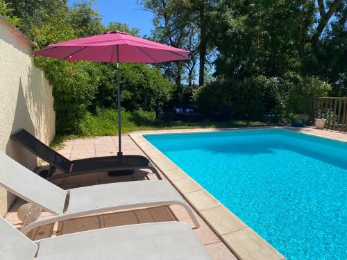 a swimming pool with two chairs and an umbrella next to it at Domaine Labatut in Tourrenquets