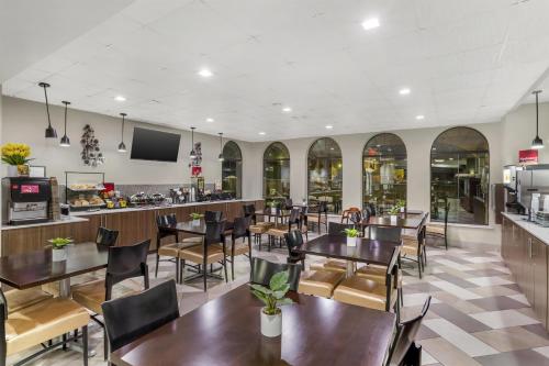 a restaurant with tables and chairs and a bar at Best Western Plus Heritage Inn & Suites Houston,Pasadena,Deer Park,Channelview in Houston