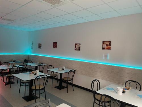 a dining room with tables and chairs and blue lights at Hotel Miramare in Savona