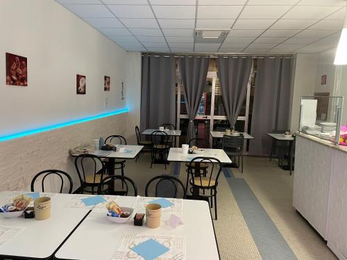 a dining room with tables and chairs and a counter at Hotel Miramare in Savona