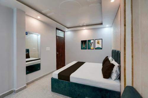 a bedroom with a bed and a mirror at HOTEL O BLUE DIAMOND in Prayagraj