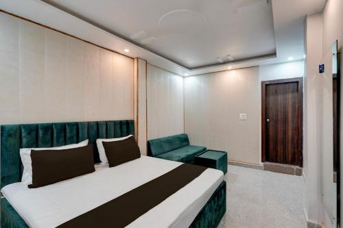 a bedroom with a bed and a green couch at Hotel O Ra One Restro & Rooms in Phūlpur