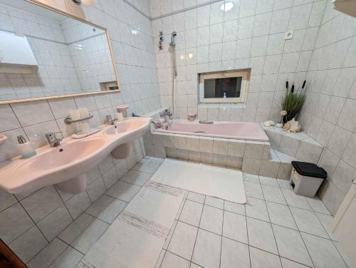 a bathroom with two sinks and a tub and a mirror at Apartment Balatonszarszo - Balaton 20085 in Balatonszárszó