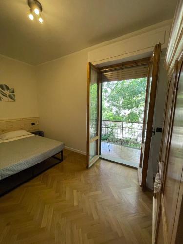 a bedroom with a bed and a door to a balcony at Villa Le Querce in Badia