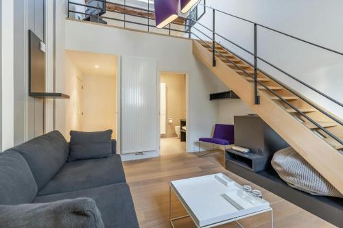 a living room with a couch and a staircase at DeuxHommes in Hasselt