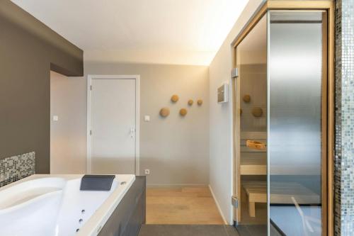 a bathroom with a tub and a shower at DeuxHommes in Hasselt