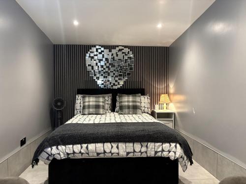 a bedroom with a bed with a black wall at The Garden Studio - Private, Modern & Peaceful Stay Near Luton Airport in Luton
