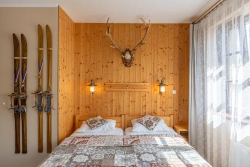 two beds in a bedroom with wooden walls at Apartman Hubert in Kašperské Hory