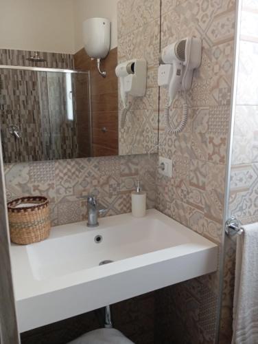 a bathroom with a white sink and a mirror at Amy Dreams in Ottaviano