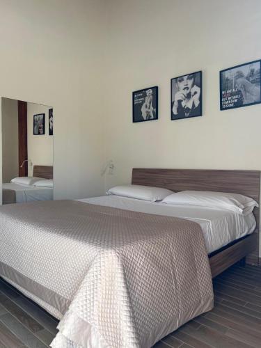 a bedroom with a large bed and pictures on the wall at Amy Dreams in Ottaviano