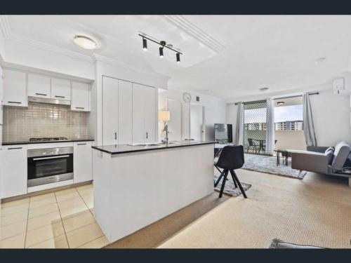 a kitchen with white cabinets and a counter top at 2-bedroom Apartment in Brisbane