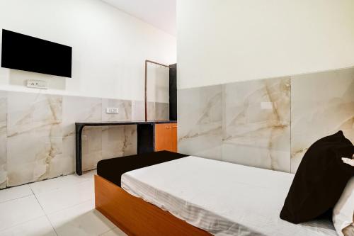 a bedroom with a bed and a tv on a wall at Hotel O Balaji Hotel & Banquet in Boisar