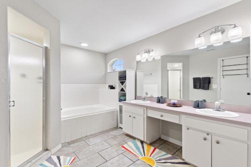 a bathroom with two sinks and a shower and a tub at Cozy 3BR 2BA Getaway Legoland Winterhaven in Lakeland