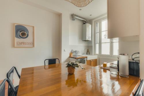 eine Küche mit einem großen Holztisch in einem Zimmer in der Unterkunft Charmant appartement 2 pièces, accès rapide Paris in Vanves