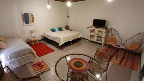 ティルカラにあるMonoambiente Tilcaraのベッド2台とテーブルとテレビのある部屋