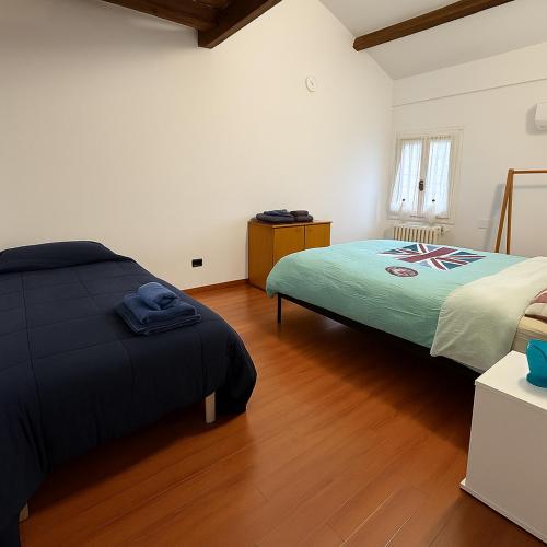 a bedroom with two beds and a wooden floor at Casa Boara in Ferrara
