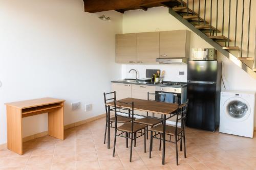 Una cocina con mesa y sillas y un refrigerador. en Casa Boara, en Ferrara