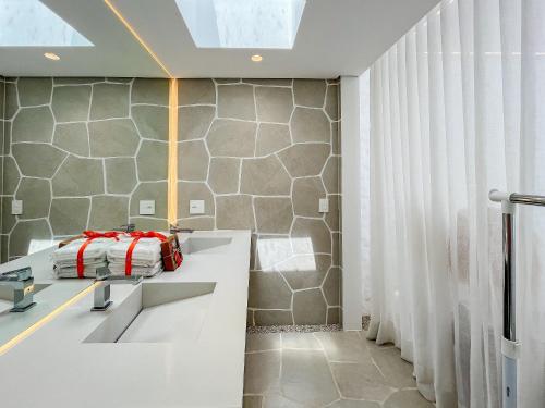 ein Badezimmer mit zwei Waschbecken und einer Dusche in der Unterkunft Riviera | Luxo e Design no Golf – Cond Privativo in Riviera de São Lourenço