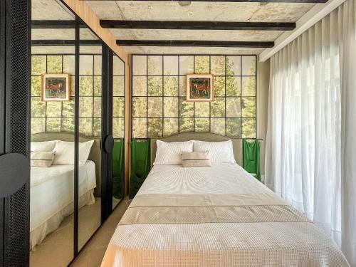 ein Schlafzimmer mit einem Bett und einem Fenster in der Unterkunft Riviera | Luxo e Design no Golf – Cond Privativo in Riviera de São Lourenço
