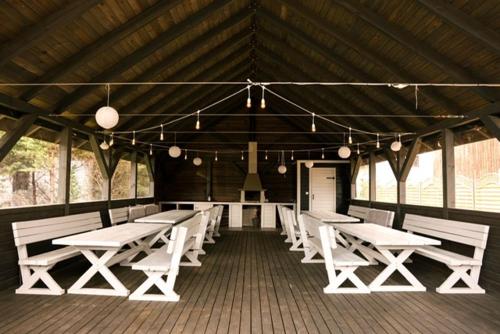 a room with white tables and benches in a building at Apartamenty Brzozowe in Okoniny Nadjezierne