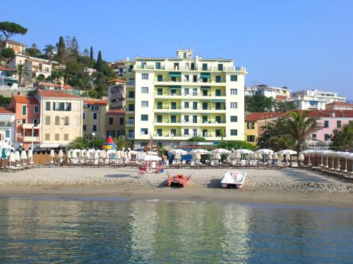 a beach with a beach house and a large body of water at Hotel Ideal in Arma di Taggia