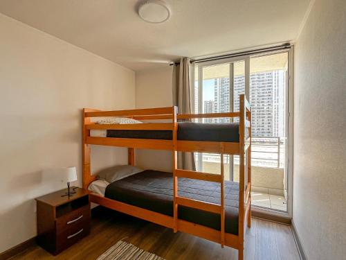 Un dormitorio con dos literas y una ventana. en Loica Host - Smart, en Santiago