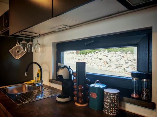 a kitchen counter with a sink and a window at KastHouse Yellow by Vellaris, Luxury Mobile Home in Mali Lošinj