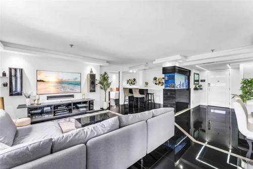 ein Wohnzimmer mit Sofa und Fernseher in der Unterkunft Modern Condo with Private Primary Suite in Ives Estates