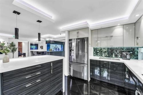 eine Küche mit weißen Arbeitsflächen und einem Kühlschrank in der Unterkunft Modern Condo with Private Primary Suite in Ives Estates