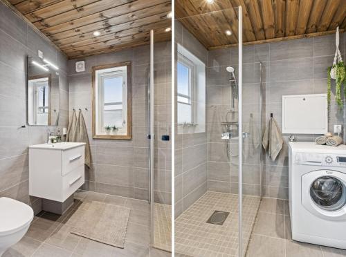 a bathroom with a washing machine and a washer at Hytte på Lygna med fantastisk utsikt in Gran