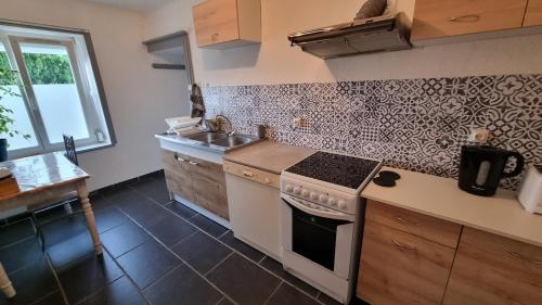 a kitchen with a stove and a sink at Champvans centre - Appartement calme et tout confort en plein centre du village in Champvans