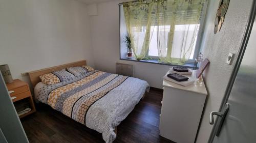 a small bedroom with a bed and a window at Champvans centre - Appartement calme et tout confort en plein centre du village in Champvans