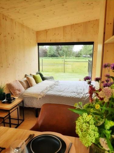 a bedroom with a bed and a large window at Black Pearl in Hamme