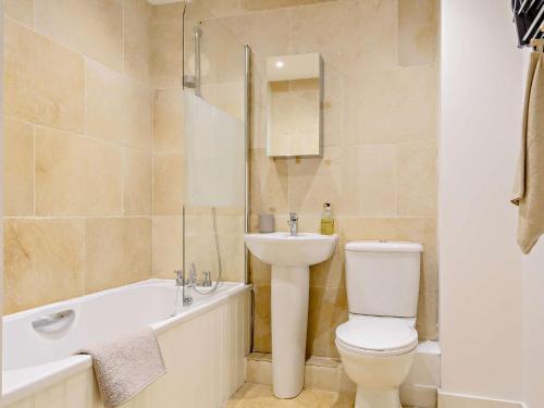 a bathroom with a toilet and a sink and a bath tub at 1 Bed in cotswolds 90128 in Cirencester