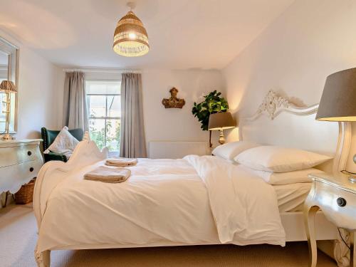 a white bedroom with two beds and a window at 1 Bed in cotswolds 90128 in Cirencester