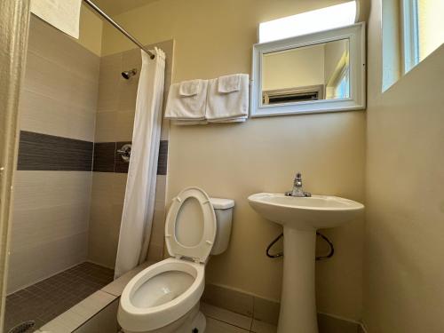 a bathroom with a toilet and a sink at American Inn in Cocoa